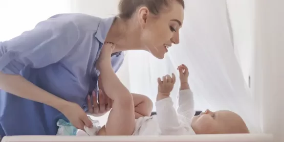 Madre cambiando la talla del pañal de su bebé